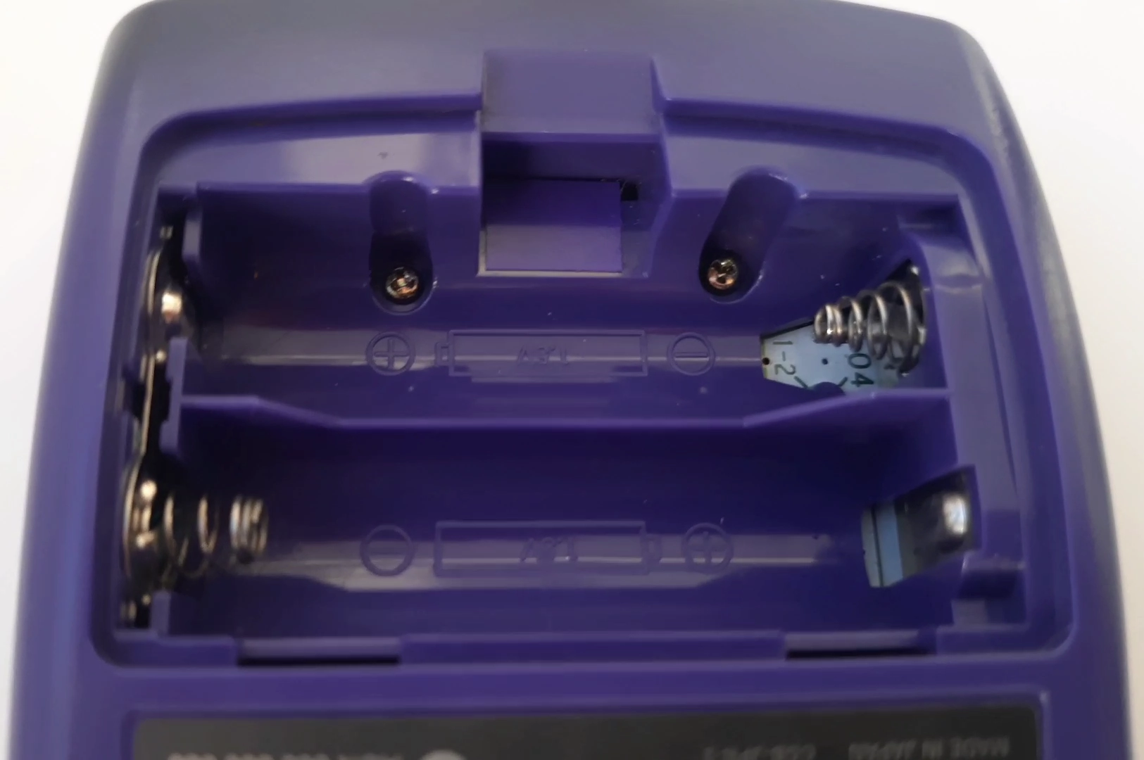 Battery compartment of a Game Boy Color, showing the holes through which the board can be seen below. This is a 04 revision. Battery compartment of a Game Boy Color, showing the holes through which the board can be seen below. This is a 04 revision.