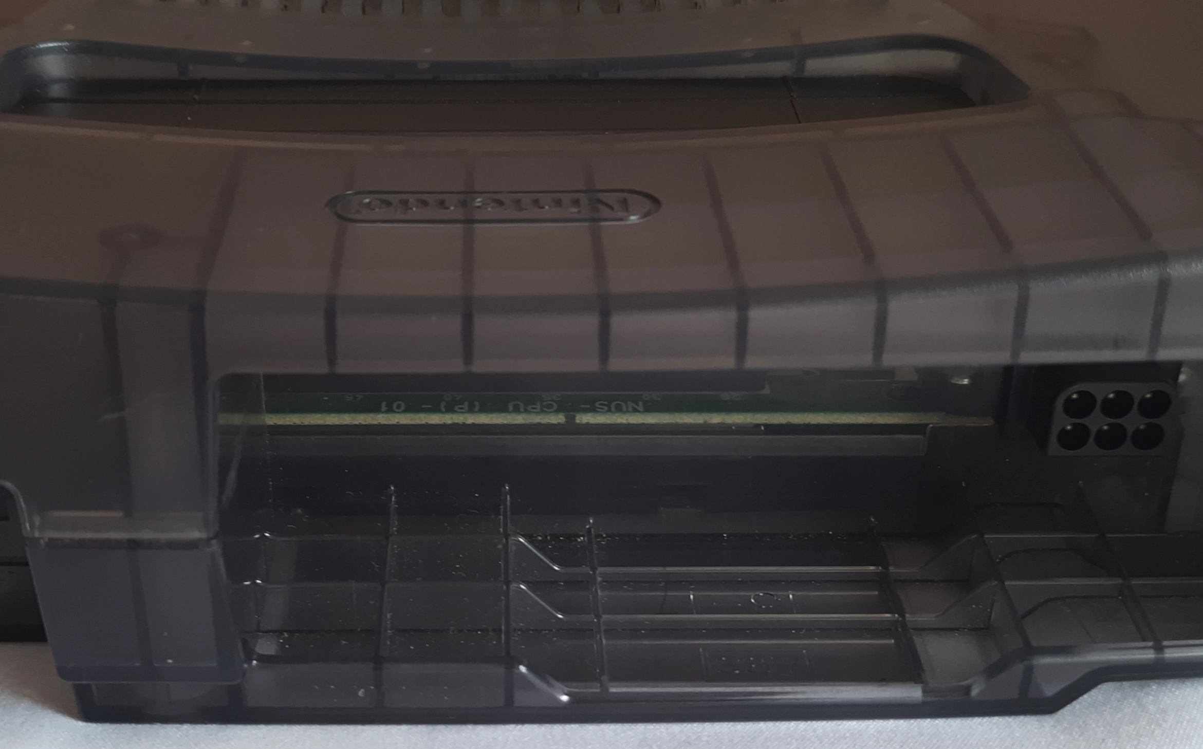 If you have a transparent N64, there's no need to open it to check the revision. Look through the hole of the PSU in the back. The one in the picture is a NUS-CPU-P-01 (zoom in and you'll see it). If you have a transparent N64, there's no need to open it to check the revision. Look through the hole of the PSU in the back. The one in the picture is a NUS-CPU-P-01 (zoom in and you'll see it).